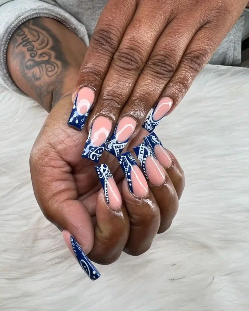 Blue bandana nail tips on acrylic nude nails.