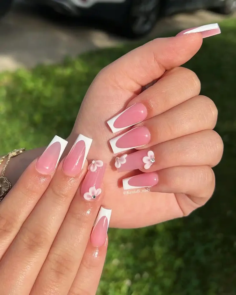 Pink and white summer nails with acrylic flower art. 