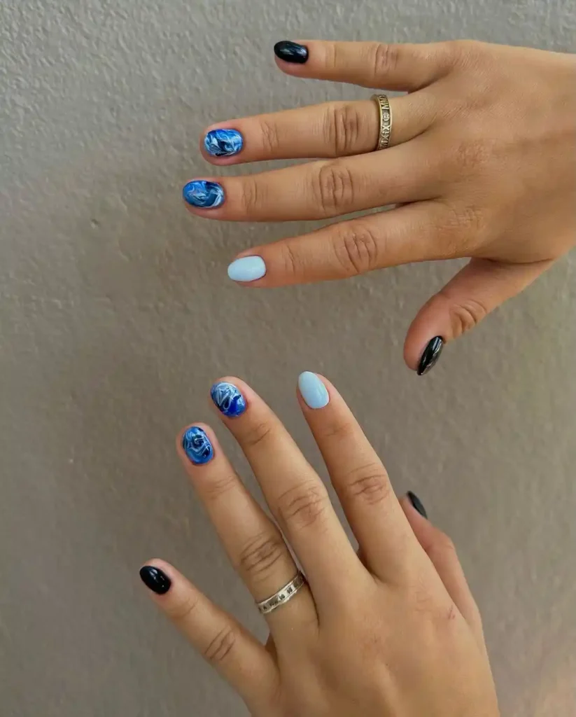 Light and dark blue marble nail art on short nails. 