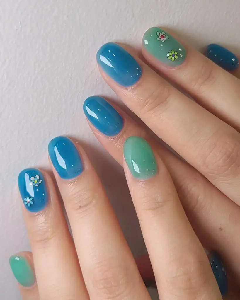 Blue and green Korean jelly nails with flower stickers.