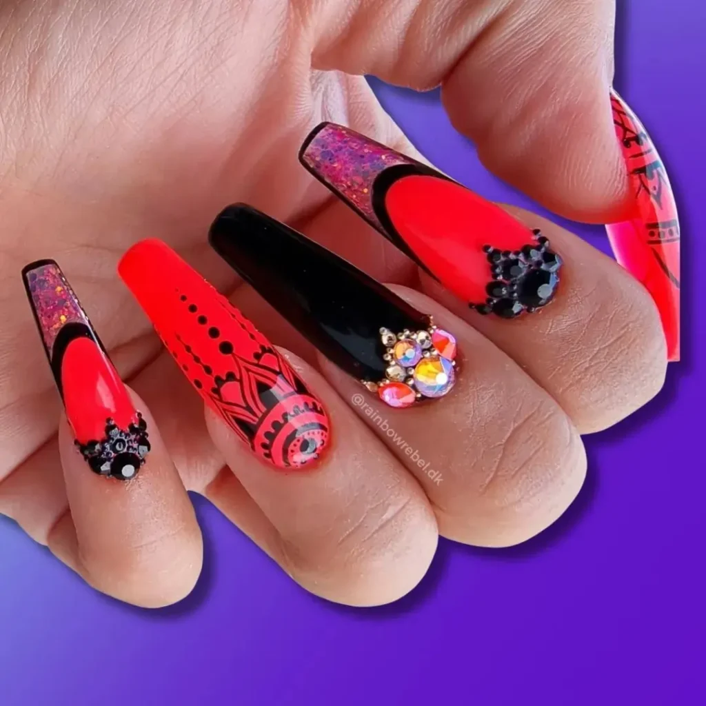 Bright orange and black nails with 3D crystal art. 