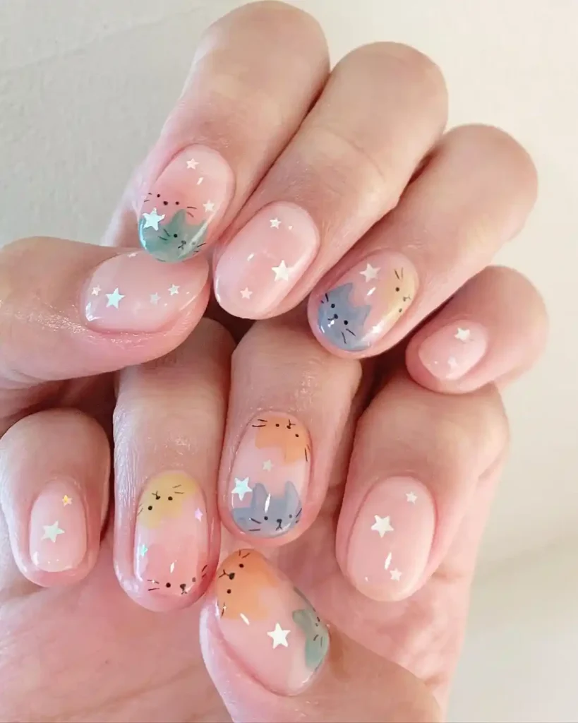 Cat and star patterns with pastel nail color on short natural nails. 