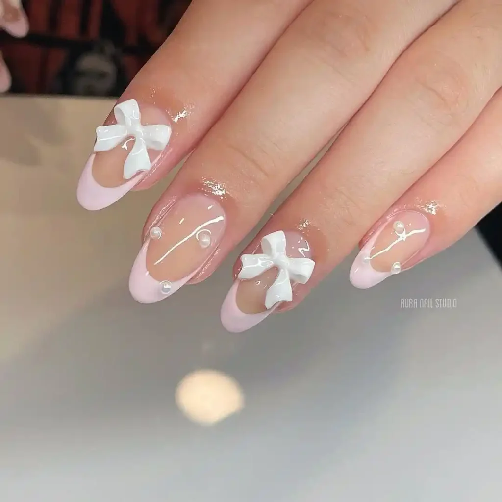 Cute pink and white coquette bow nails with pink French tips and acrylic bow.