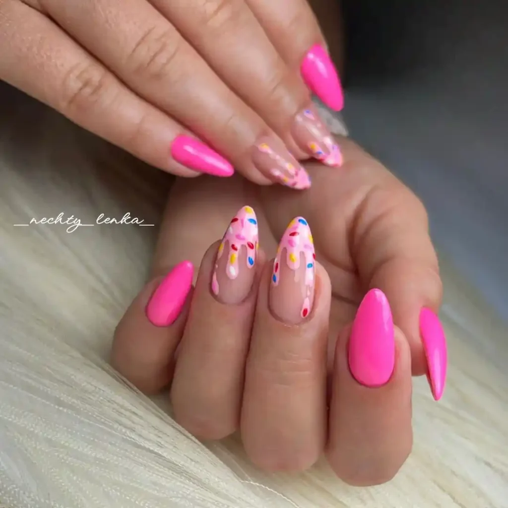 Cute pink almond nails with donut dripping and sprinkles nail art.