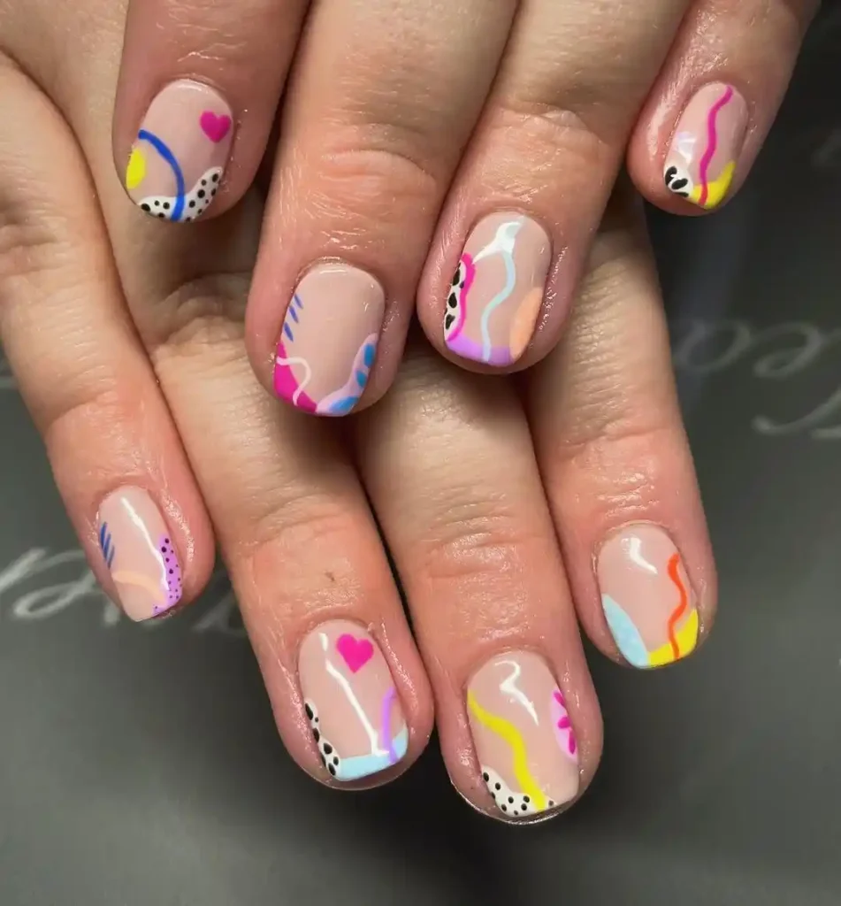 Funky holiday nails with a nude base and colorful nail art. 
