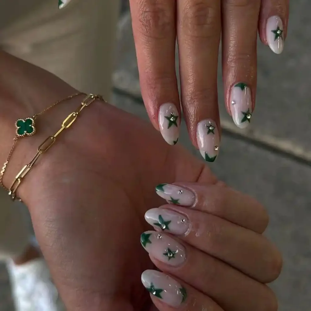 Cute star manicure with a neutral base and green star patterns for fall. 