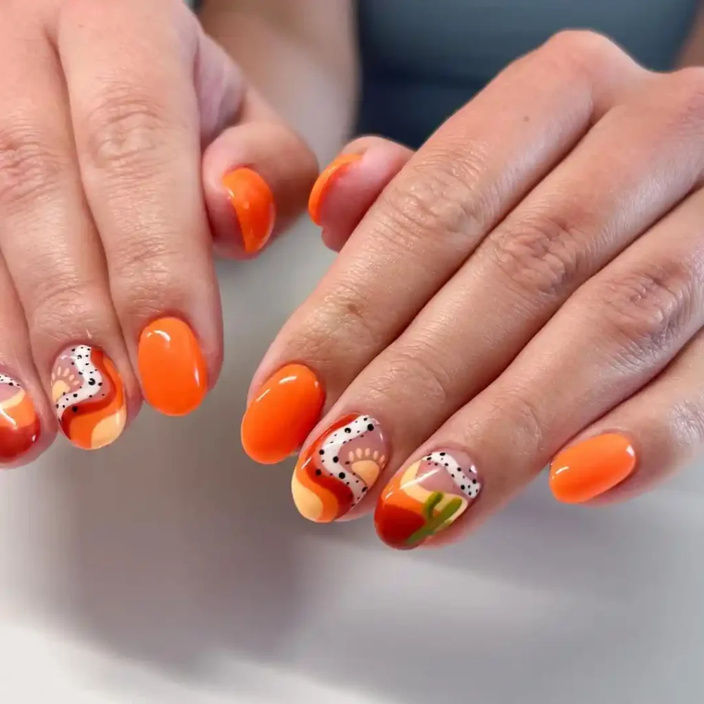 Western desert nail ideas with orange and brown nail colors. 