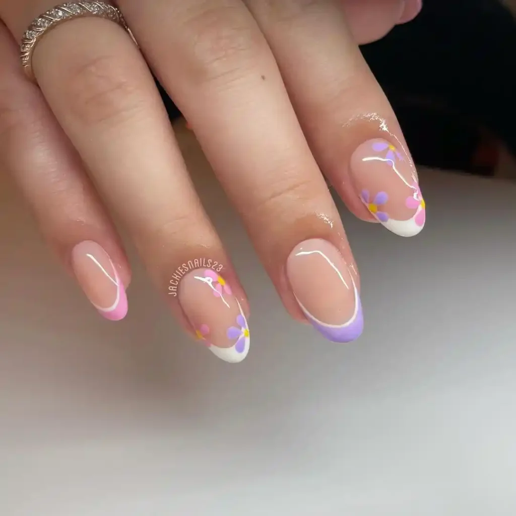 Pastel French tips with flower patterns for spring manicure. 