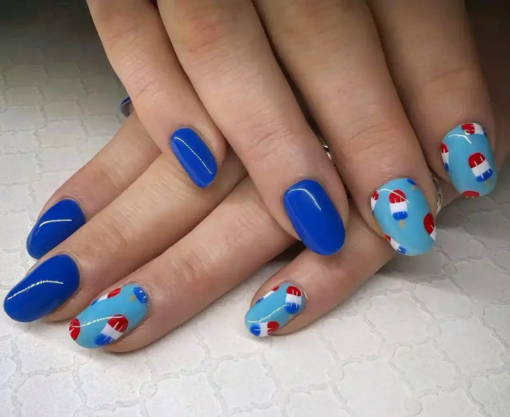 Cute popsicle designs on short blue summer nails.