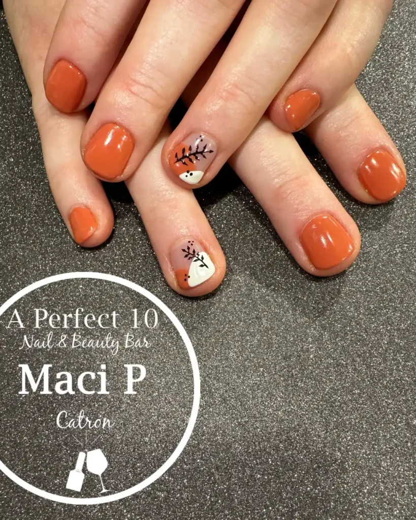 Short orange nails with simple abstract art for pumpkin season. 