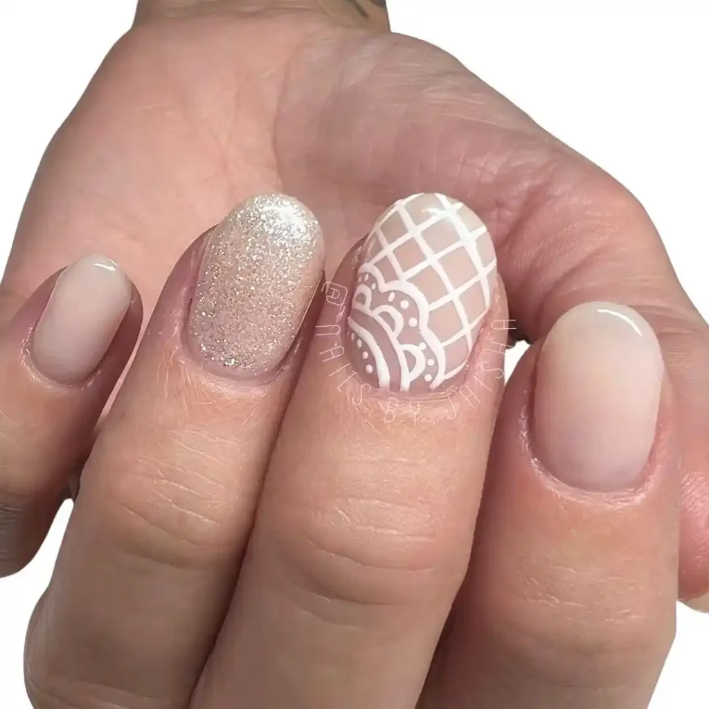 Vintage white lace nail art on short nude nails. 