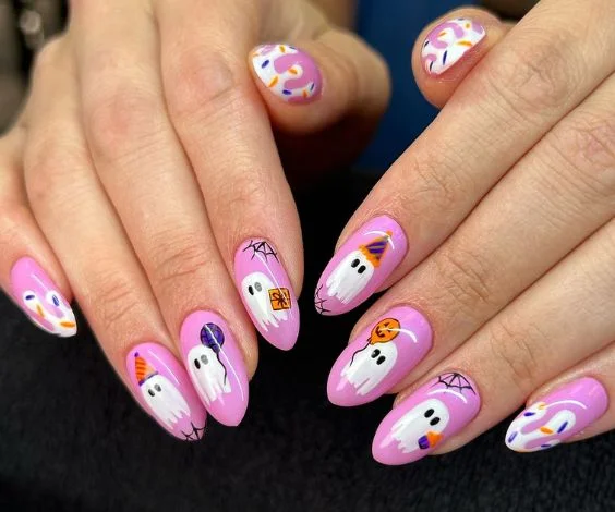 Pink almond nails with cute ghost nail art for the Halloween season.