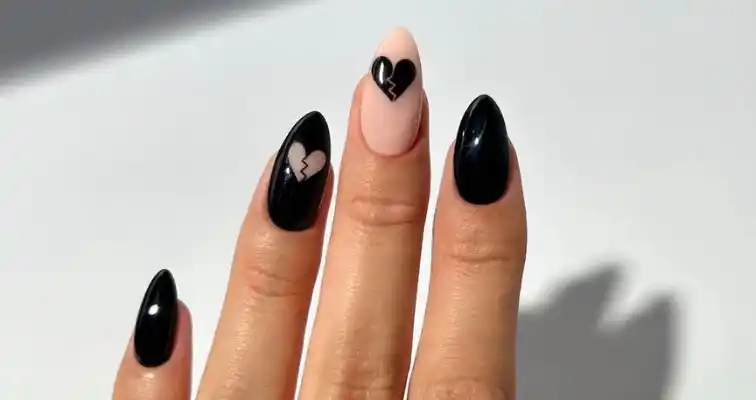 Black nails for Valentine's Day with heart nail designs. 