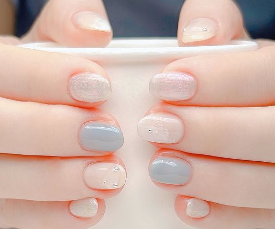 Cute blue and white Korean nail art on short nails.