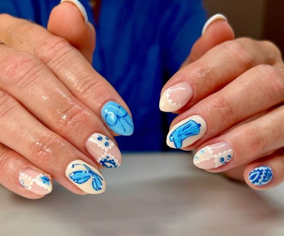 Cute blue cowgirl nails with bandana, boots, and lace nail art. 