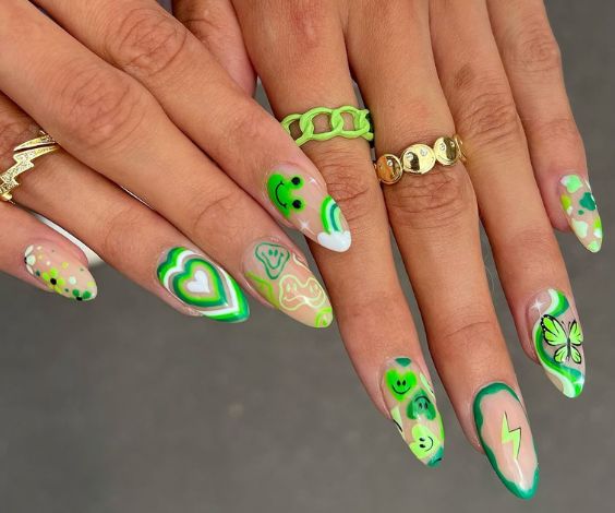 Green holiday nails with doodle, heart, and butterfly designs. 