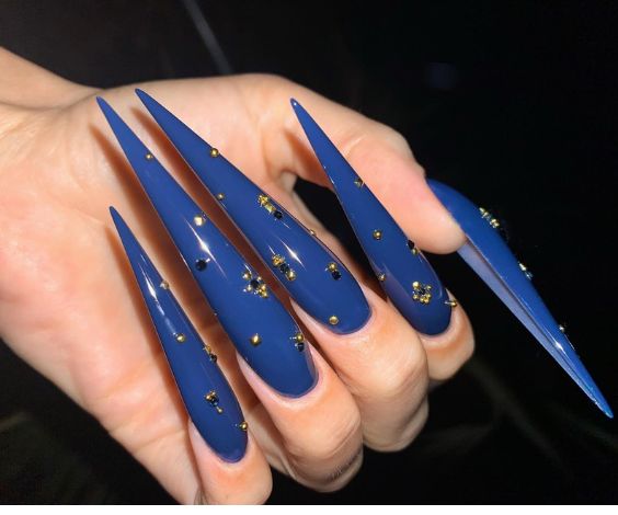 Long stiletto nails with copper nail studs. 