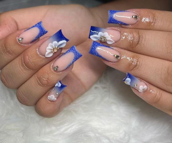 Royal blue ombre and French tips with acrylic flowers. 