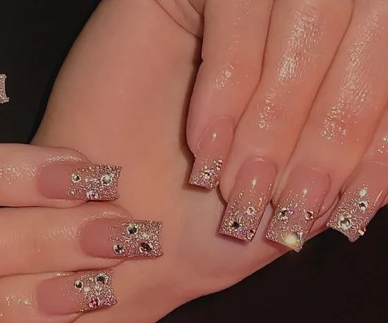 Medium square nails with glitter nude nail design. 