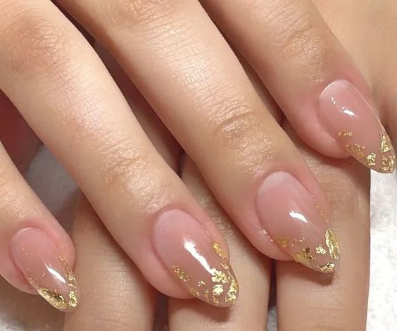 Simple nude nails with gold foil French tips.