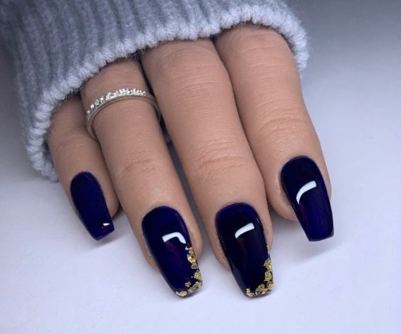 Medium coffin nails with navy blue nail color and gold foil tips. 