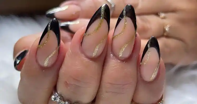 Black almond French tips with gold glitter swirls art. 
