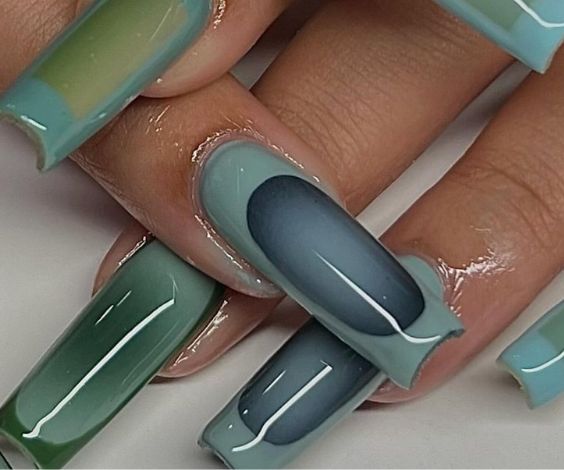 Green and blue acrylic nails with abstract art.