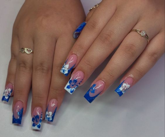 Medium square nails with white and blue French tips and hibiscus flower art.