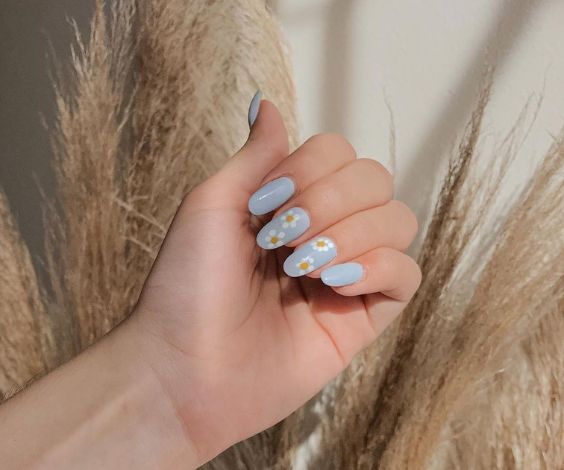 Light pastel blue nails with spring white flower designs.