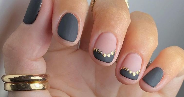 Matte black short nails with metallic gold details.