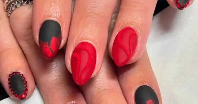 Cute short almond nails with red and black glitter, stones, and still nail art.