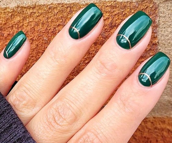 Simple forest green nails with metallic gold half-moon art. 
