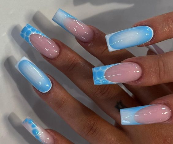 Blue acrylic nails with French tips and aura effect. 