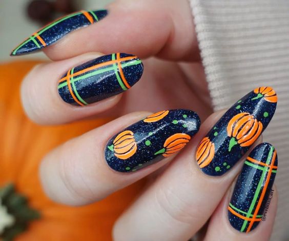 Dark blue nails with pumpkin nail art.