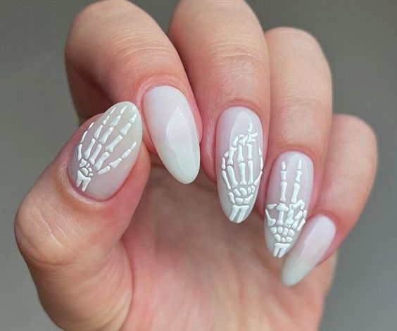 Milky white nails with skeleton hand design. 