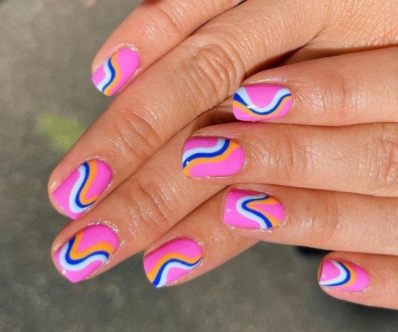 Bright pink and blue nail colors on short round nails. 