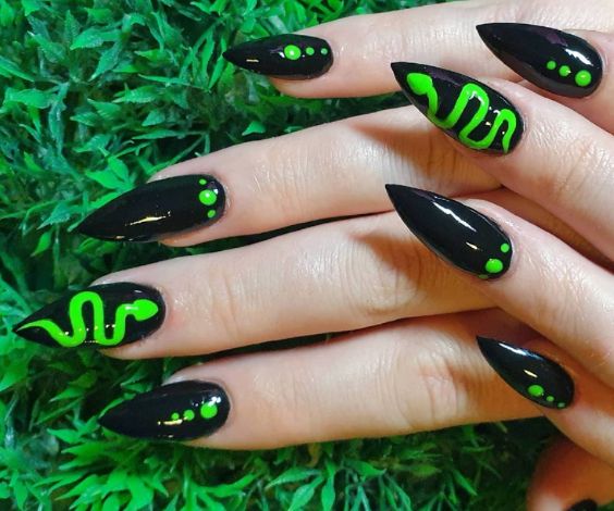 Venom and dots pattern on black stiletto nails with neon green nail color. 
