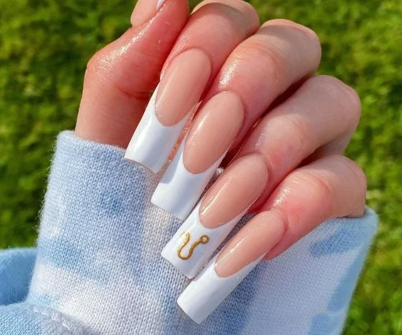 Classic white French tips with metallic gold Leo sign.