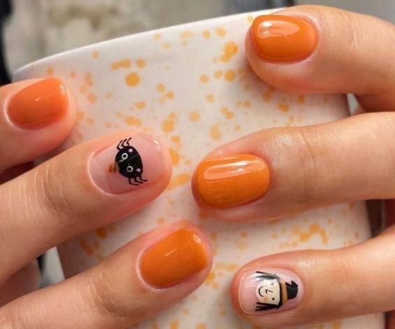 Cute witches nail designs with orange nail color 